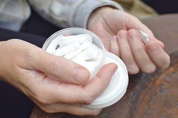 person holding a container of pouches